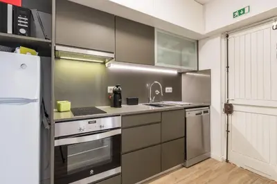 a kitchen with stainless steel appliances and a refrigerator at LovelyStay - Green Oasis Villa in Vilamoura