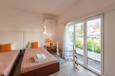 a room with two beds and a large window at LovelyStay - Green Oasis Villa in Vilamoura