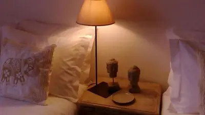 a lamp on a night stand next to a bed at Casa da Praia in Albufeira