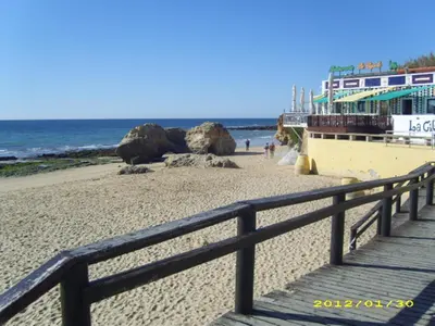a boardwalk on a beach next to the ocean at Casa da Praia in Albufeira