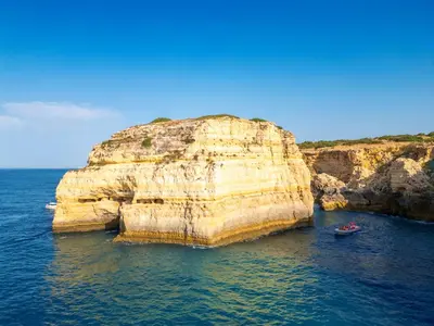 a large rock formation in the water with two boats at Apartment Portofino 1 by Algarve Vacation in Vilamoura