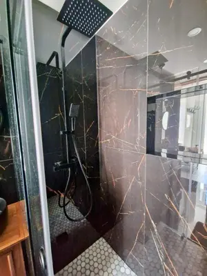 a bathroom with a black and brown marble wall at RECANTO da FELICIDADE in Albufeira