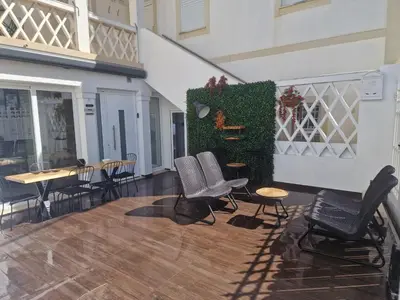 a patio with two chairs and a green wall at RECANTO da FELICIDADE in Albufeira