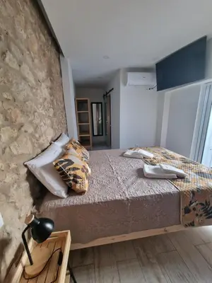 a bedroom with a bed and a stone wall at RECANTO da FELICIDADE in Albufeira