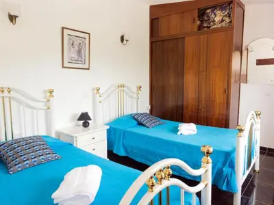 two beds in a bedroom with blue sheets at Villa V4 Filomena in Mosqueira