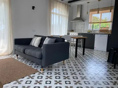 a living room with a couch and a kitchen at Casa Herdeiro in Faro