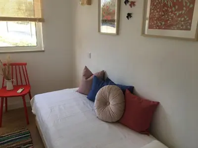 a bedroom with a bed with blue and red pillows at Casa Herdeiro in Faro
