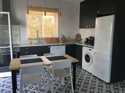 a kitchen with a table and chairs and a refrigerator at Casa Herdeiro in Faro
