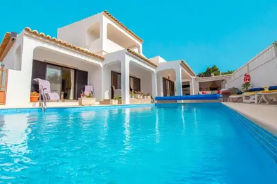 a villa with a swimming pool in front of a house at Villa Thai by Algarve Vacation in Albufeira