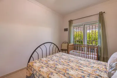 a bedroom with a bed and a window at Apart Encosta S Jose - Piscina - Estacionamento in Guia