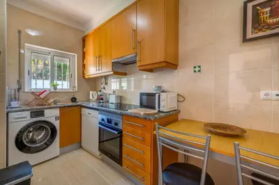 a small kitchen with a table and a microwave at Apart Encosta S Jose - Piscina - Estacionamento in Guia