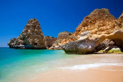 a view of a beach with rocks in the water at Golden Palm Condo by BeCherish in Albufeira