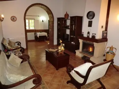 a living room with a fireplace and chairs and a table at Monte dos Avós in Querença