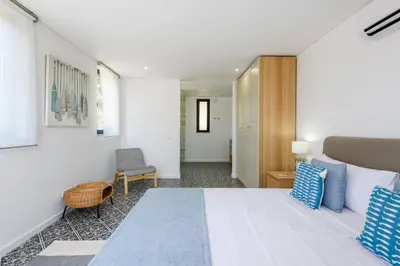a bedroom with a large white bed with blue pillows at Casa dos Sonhos, Vale do Lobo in Almancil