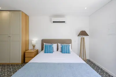 a bedroom with a large bed with blue pillows at Casa dos Sonhos, Vale do Lobo in Almancil