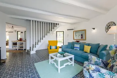 a living room with a blue couch and a yellow chair at Casa dos Sonhos, Vale do Lobo in Almancil
