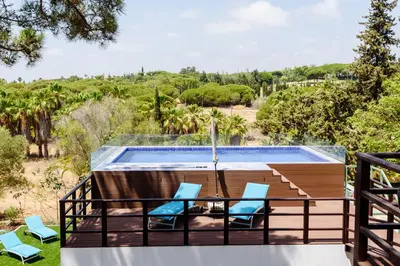 a deck with two chairs and a swimming pool at Casa dos Sonhos, Vale do Lobo in Almancil
