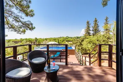 a balcony with chairs and a table on a deck at Casa dos Sonhos, Vale do Lobo in Almancil