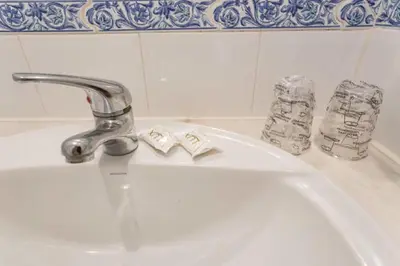 a bathroom sink with a faucet and two toothbrushes at Residencial Capri by Umbral in Albufeira