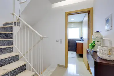 a hallway with a staircase and a mirror at Casa Maguy in Albufeira