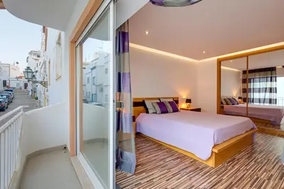 a bedroom with a bed and a balcony at Casa Maguy in Albufeira