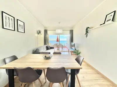 a dining room with a wooden table and chairs at Sea Front 180º View with AC and WiFi in Quarteira