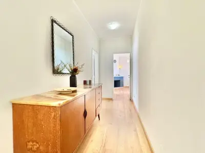 a room with a wooden dresser and a mirror at Sea Front 180º View with AC and WiFi in Quarteira