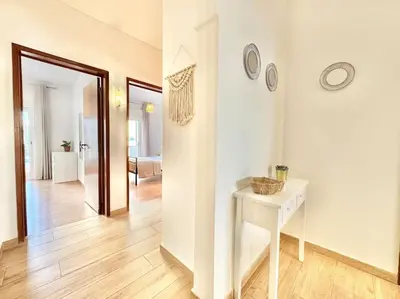 a white hallway with a white table and a room at Direct Beach Access with Sea View, AC & WiFi in Quarteira