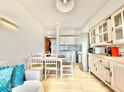 a kitchen with a table and a dining room at Direct Beach Access with Sea View, AC & WiFi in Quarteira