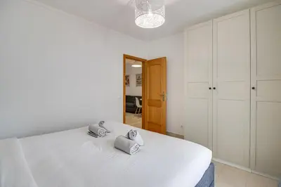 a bedroom with a large white bed with two pillows on it at Cozy Apt 5min Beach Ocean View AC Wi Fi in Albufeira