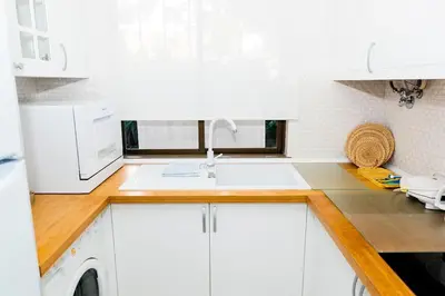 a kitchen with white cabinets and a sink at The Albufeira Concierge - Villa Praia São Rafael in Albufeira