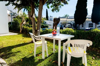 a white table and two chairs on the grass at The Albufeira Concierge - Villa Praia São Rafael in Albufeira