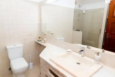 a bathroom with a sink and a toilet and a mirror at The Albufeira Concierge - Villa Praia São Rafael in Albufeira