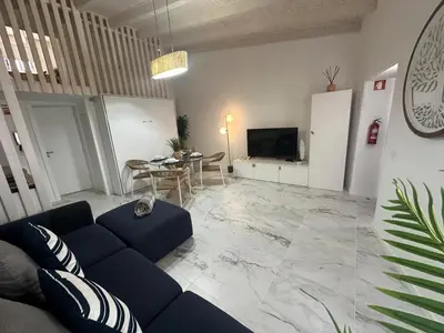 a living room with a blue couch and a table at Alcaçarias Suite 20 in Faro