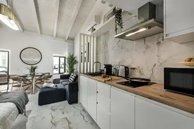 a kitchen with white cabinets and a counter top at Alcaçarias Suite 20 in Faro