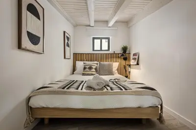a bedroom with a large bed with white walls at Alcaçarias Suite 20 in Faro
