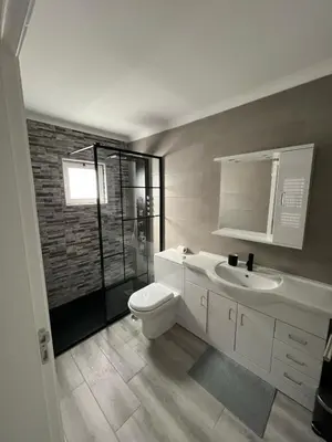 a bathroom with a shower and a sink and a mirror at Villa Feliz - Large Villa - Pool in Albufeira