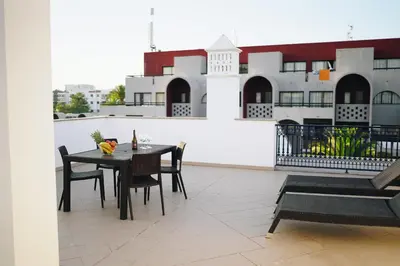 a table and chairs on the balcony of a building at Host Wise - Wonderful Flats with Pool in Albufeira
