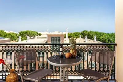 a table with a pineapple sitting on a balcony at Host Wise - Wonderful Flats with Pool in Albufeira