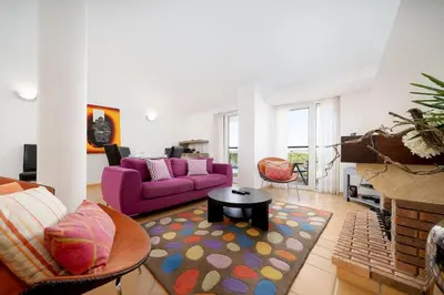 a living room with a purple couch and a table at 2 bedroom apt Vila Sol in Quarteira