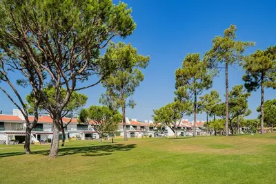 a park with trees in front of a building at 2 bedroom apt Vila Sol in Quarteira