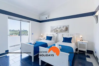 two beds in a bedroom with an orange sign that says home holidays at #248 Villa Loureira 54 by Home Holidays in Albufeira