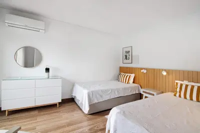 a bedroom with two beds and a mirror at Pear Tree Villa in Vale do Lobo