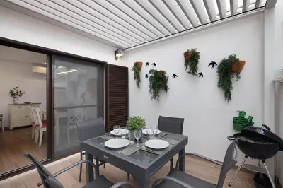 a dining room with a table with plants on the wall at Pear Tree Villa in Vale do Lobo