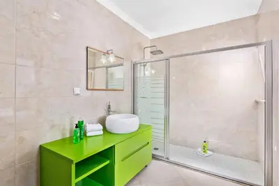 a bathroom with a green sink and a shower at Villa Helene Norvilla in Galé