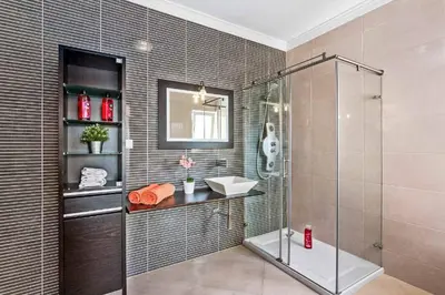 a bathroom with a glass shower and a sink at Villa Helene Norvilla in Galé
