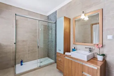 a bathroom with a shower and a sink and a mirror at Villa Helene Norvilla in Galé