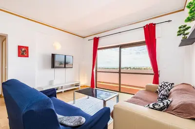 a living room with a couch and a glass table at TAC - Sunrise Montechoro Albufeira in Albufeira