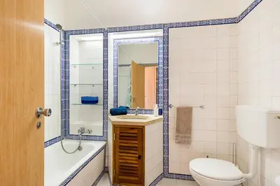 a bathroom with a toilet and a tub and a sink at TAC - Sunrise Montechoro Albufeira in Albufeira