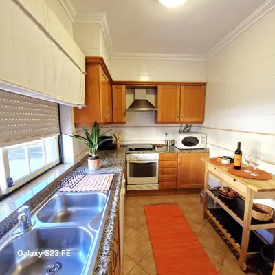 a kitchen with wooden cabinets and a blue sink at Moradia V2 - 200m da Praia da Oura - Santa Eulália in Albufeira